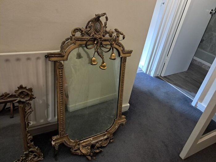 Two distinct antique giltwood mirrors with elaborate French-style ornamentation