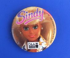 DOLLOND & AITCHISON (high-street opticians) - a promotional button badge featuring a Sindy doll (1990s)
