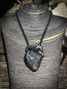 Anatomical heart made from black polymer clay with silver details on black rope