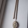 A large medallion featuring religious symbols, suspended from a long chain. Image 5