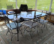 A Luxury Wrought Iron and Smoked Glass Dining Set With 8 Chairs