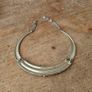 choker necklace. It combines a rigid metallic collar band with an intricately layered bohemian bib display. Image 2