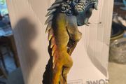 handmade iguana on natural wood log