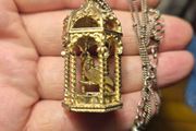 Vintage gilded bird cage with a bird pendant.