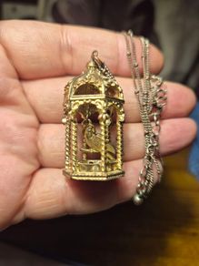 Vintage gilded bird cage with a bird pendant.