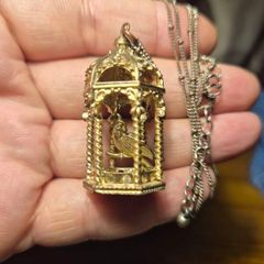 Vintage gilded bird cage with a bird pendant.