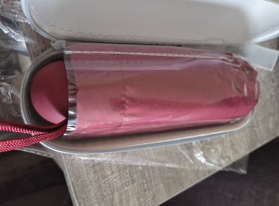 Umbrella with protective zip case. Burgundy/red colour, lightweight and easy to carry in a handbag or backpack. Brand new and unused.
