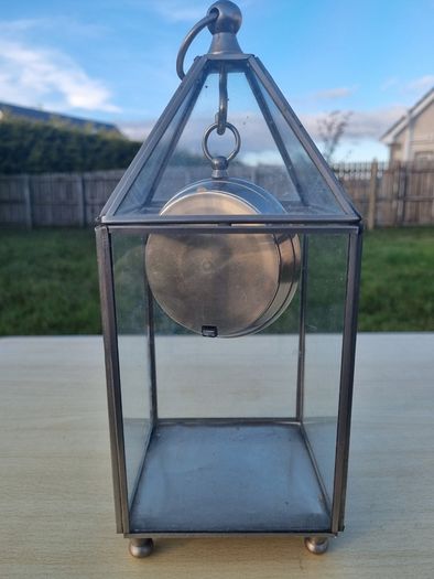 Table clock in a glass lantern.