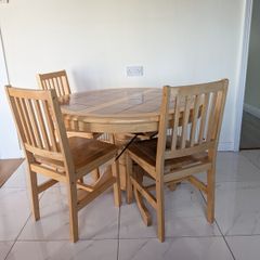 solid pine pedestal dining table with 4 matching four slatted wooden chairs.