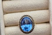 Beautiful 9K gold ring featuring a stunning large oval blue stone.