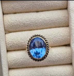 Beautiful 9K gold ring featuring a stunning large oval blue stone.