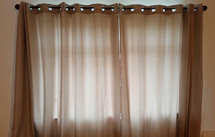 Textured light brown swirl patterned eyelet curtains from The Glenmount Collection made of polyester  size h 230cm, w 220cm (each)