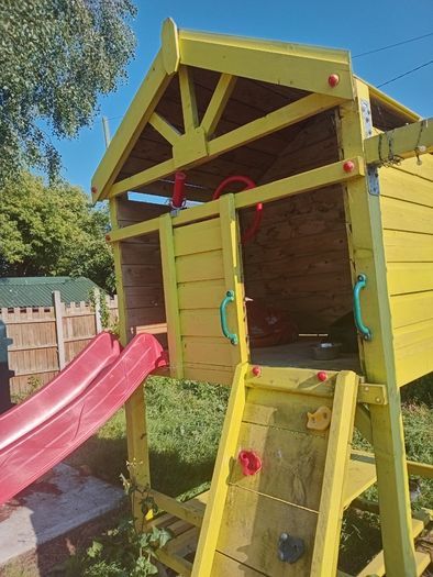 Playhouse with swings, slide, look out tower, picnic table and basketball hoop