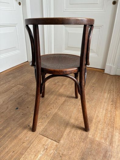 A vintage 1920s Thonet style bentwood chair with armrests.