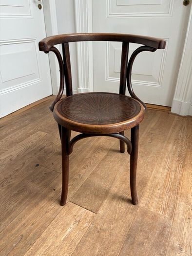 A vintage 1920s Thonet style bentwood chair with armrests.