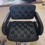 2 black faux leather bar stools with padded seats, armrests and chrome bases. Image 2
