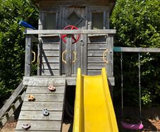 treehouse with swings slide climbing wall and gym bar