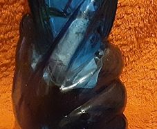 very unusual blue vase held in a hand