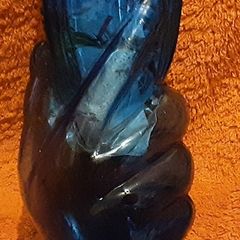 very unusual blue vase held in a hand