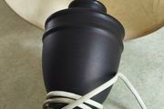Small black carmic table lamp and shade in working order.38 cm, tall all togther.