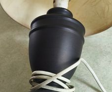 Small black carmic table lamp and shade in working order.38 cm, tall all togther.