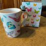 Butterfly Shaped Handle Ceramic Mug, decorated with various colorful butterfly graphics. 3D ceramic butterfly molded directly onto the handle. New in Box. Image 4