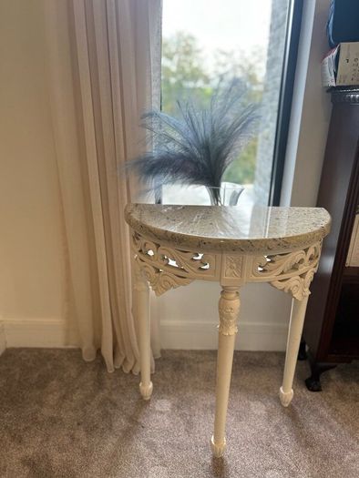 ornate half-moon console table with a granite top