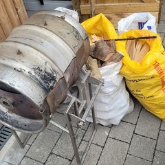 This handmade stainless steel grill features a stainless steel base and 6 bags of firewood.