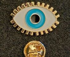 The evil eye, pin back badge.