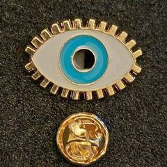 The evil eye, pin back badge.