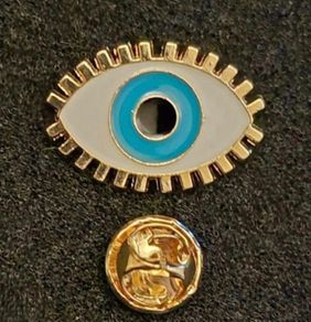 The evil eye, pin back badge.