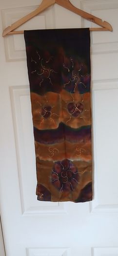 Hand painted, 100% silk scarf featuring a hand-rolled hem and custom metallic gutta detailing.