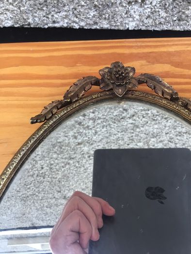 Brass framed ornate oval mirror