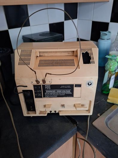 Ideal Prop, Vintage Working Boots Audio TV12 Portable Black and White CRT Television, featuring a cream plastic casing with side control dials and a 12 inch screen. Designed with dual power capabilities supporting standard mains voltage (240V) as well as 