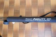 Shakespeare Agility Spin fishing rod. 11 feet (3.30 meters) in length. The item includes a black carrying tube with a strap for transport.