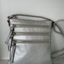 Silver crossbody handbag with contrasting gold zips & hardware  In excellent condition. Purchased in Toulouse Image 3