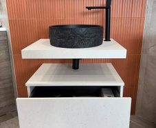 Modern wall-mounted vanity unit with black basin and tap