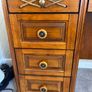Crafted from stained hardwood with raised drawer panels, rounded pedestal edges, and an arched top mirror crown bordered by heavy metal or wood accent brackets. Nautical Rope Detailing: The upper accent panels on the mirror frame, the top left drawer, and Image 3