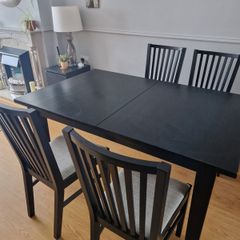 Black dining table with four chairs