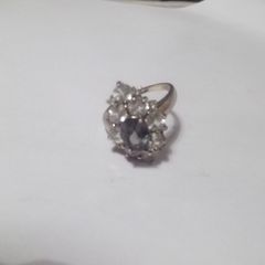 a silver dress ring with 10 white stones and purple stone