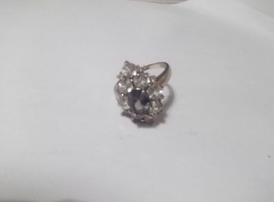 a silver dress ring with 10 white stones and purple stone