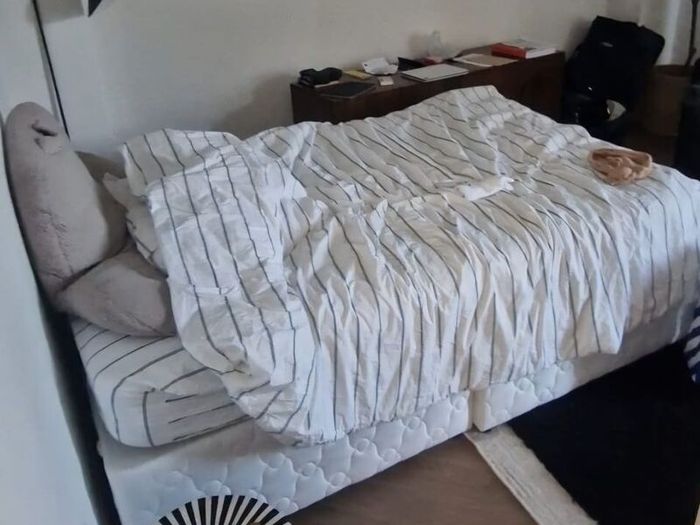 Double bed with mattress and table.