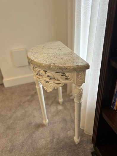 ornate half-moon console table with a granite top