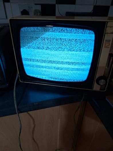 Ideal Prop, Vintage Working Boots Audio TV12 Portable Black and White CRT Television, featuring a cream plastic casing with side control dials and a 12 inch screen. Designed with dual power capabilities supporting standard mains voltage (240V) as well as 