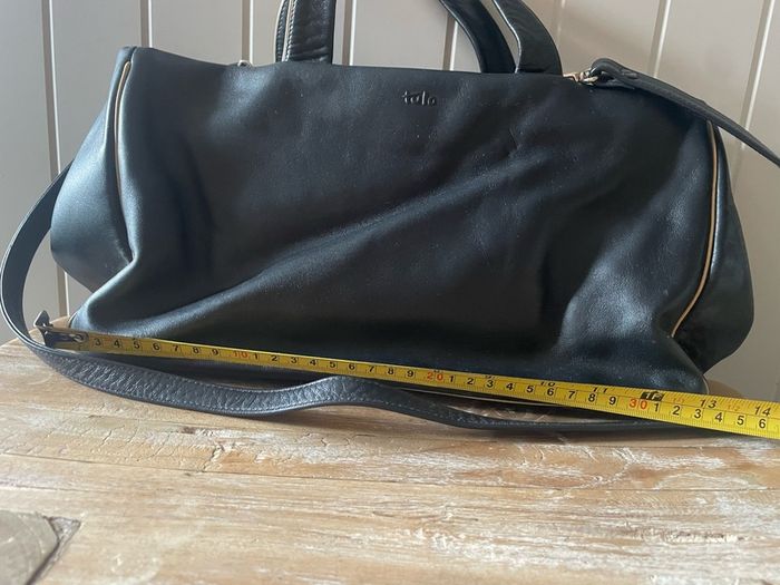 Tula black leather tote bag with a shoulder strap.