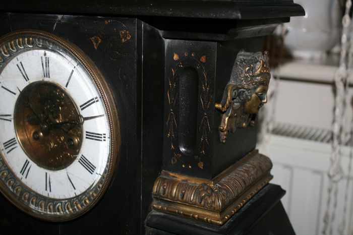 Victorian French Black Slate Mantle Clock (Very large and heavy) with bronze ornamentation Oversized. Open escarpment slate plate Roman numerals. Circa 1890s. Accented with Trojan head. Flanked by two Hellenistic ladies heads on sides. Rose cartouche mask