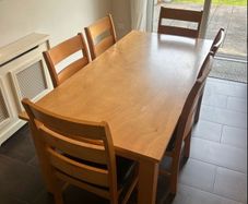 Solid wood dining table. Damage on corner as shown in photos.