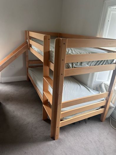 Bunk bed with attached slide and mattresses