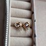 Beautiful silver and rose gold-tone knot stud earrings. Image 4