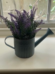 Faux plant in a watering can